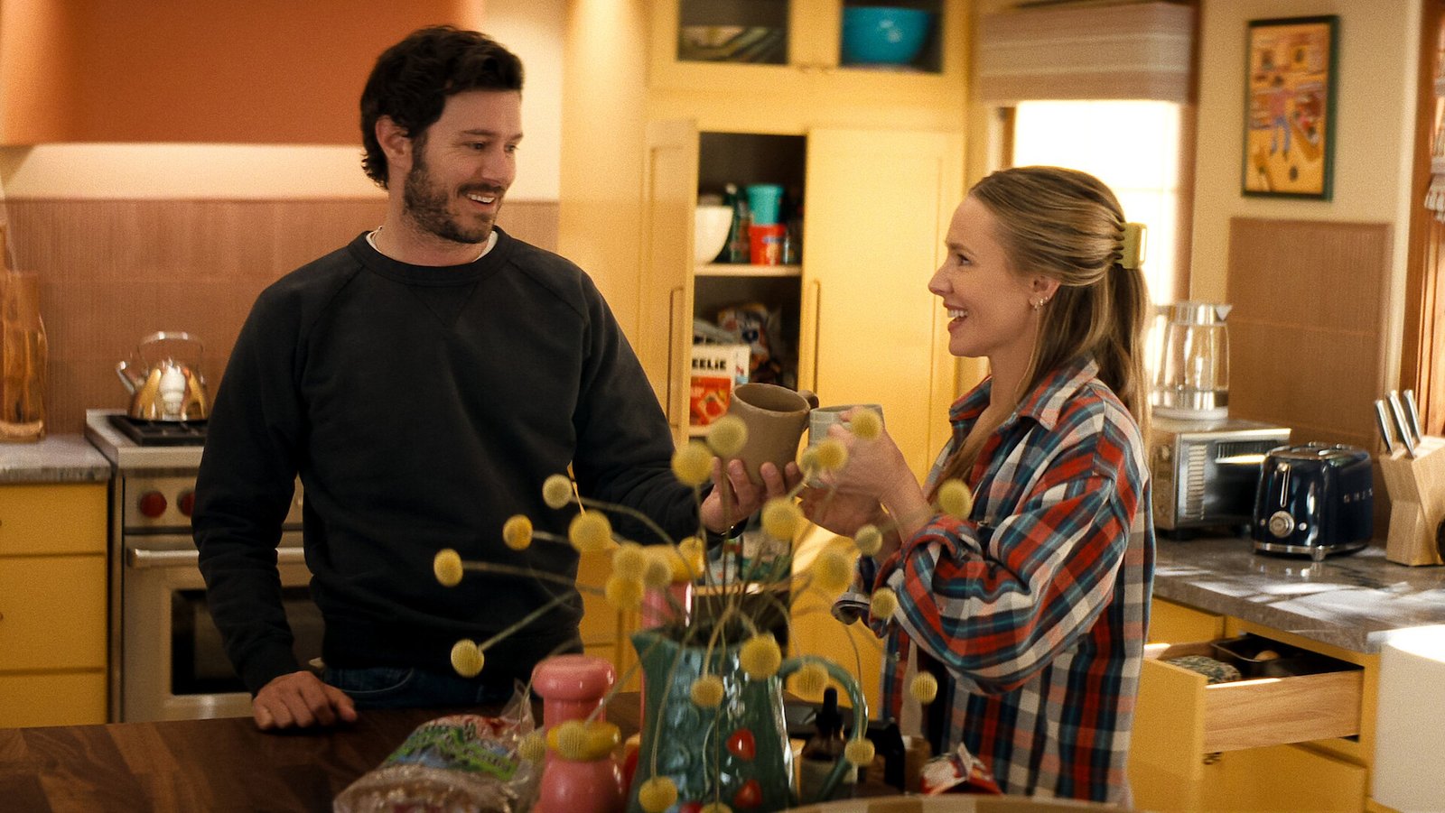Nobody Wants This dizisinden Kristen Bell ve Adam Brody’nin mutfakta kadeh tokuşturduğu Tudum press karesi