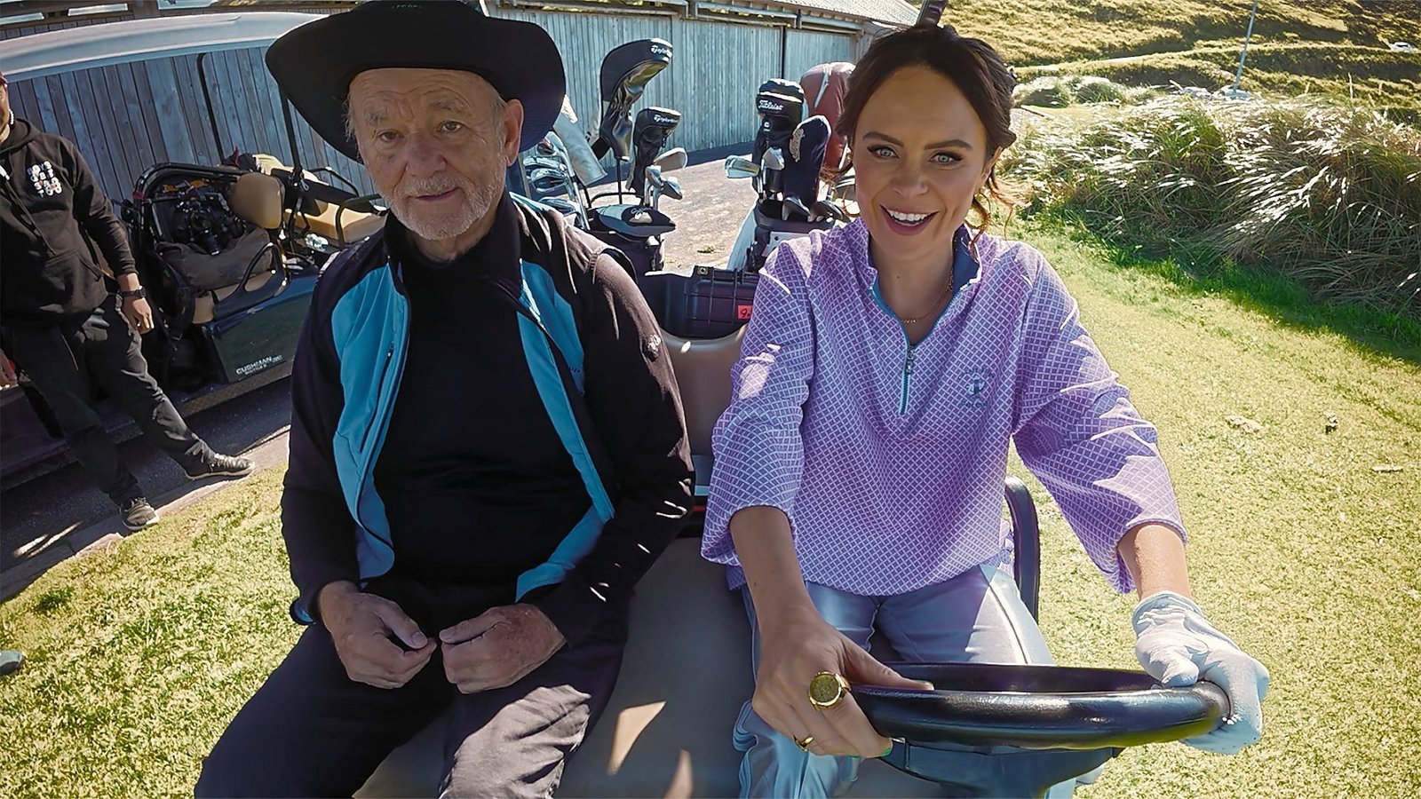 A Course Called Ireland resmi karesinden golf arabasında oturan Bill Murray ve direksiyondaki Joanne McNally