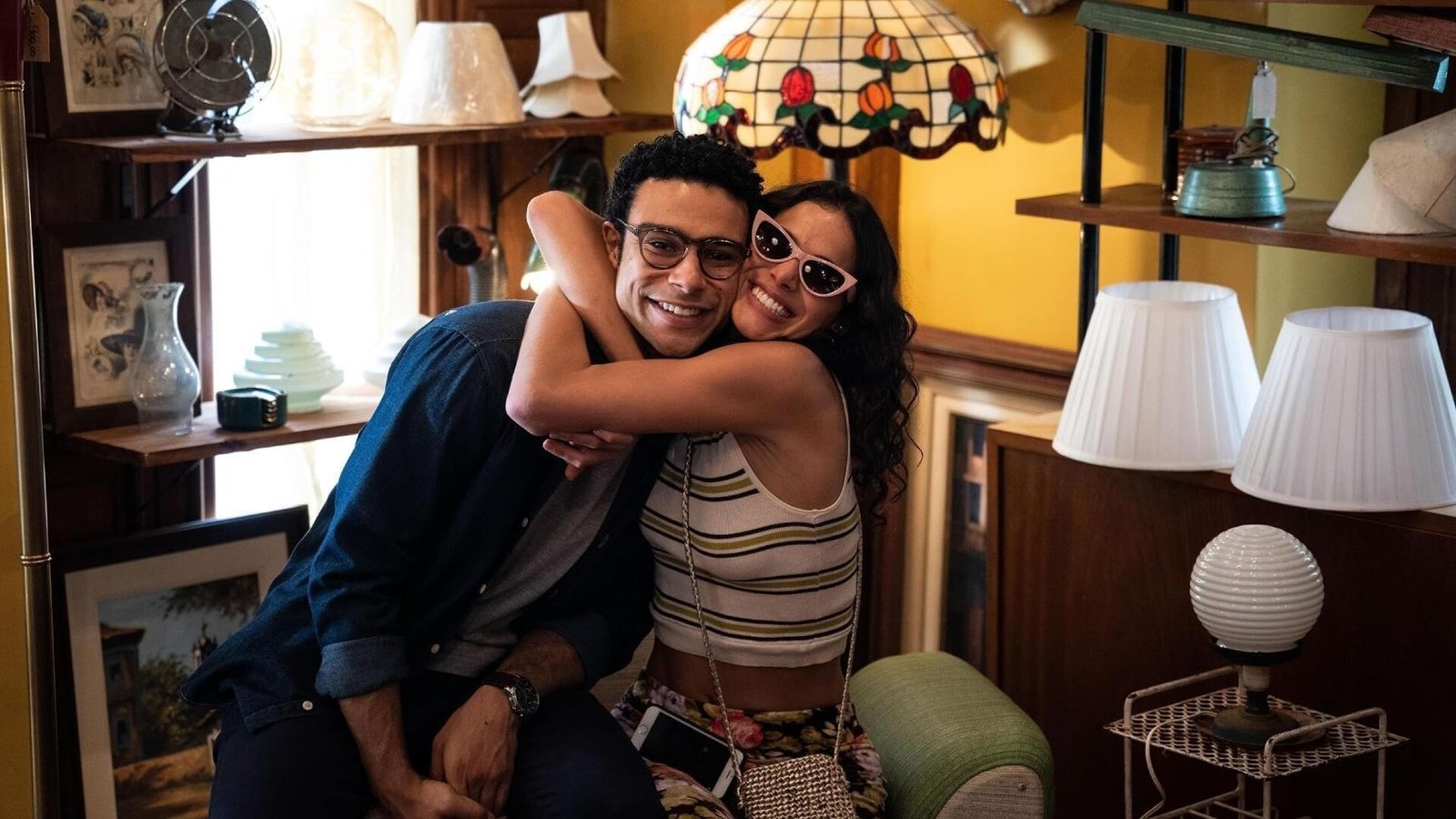Amor da Minha Vida 2. sezon 9 Ekim’de Disney+’ta: Bruna Marquezine ve Sérgio Malheiros geri döndü 2026 – 1 Amor da Minha Vida Disney+ resmi karesinden lambalarla dolu bir mekânda birbirine sarılan gözlüklü bir adam ve güneÅŸ gözlüklü bir kadın