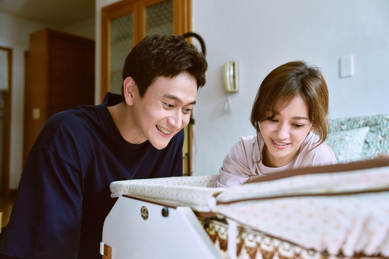 Driving Mom Crazy resmi karesinden bebek beşiğine eğilerek gülümseyen Liu Kuan-ting ve Ivy Chen