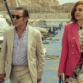 Fading Grandeur Netflix resmi karesinden bir marinada yürüyen Antonio de la Torre ve pembe ceketli Alexandra Jiménez