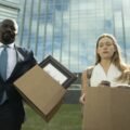 Cupertino CBS resmi karesinden Mike Colter ve Rachel Keller ellerinde kolilerle binadan çıkıyor
