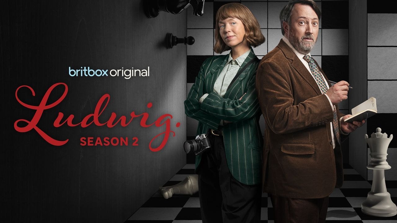 Ludwig 2. sezon BritBox resmi tanıtım görseli, satranç tahtası önünde Anna Maxwell Martin ve elinde bulmaca kitabıyla David Mitchell