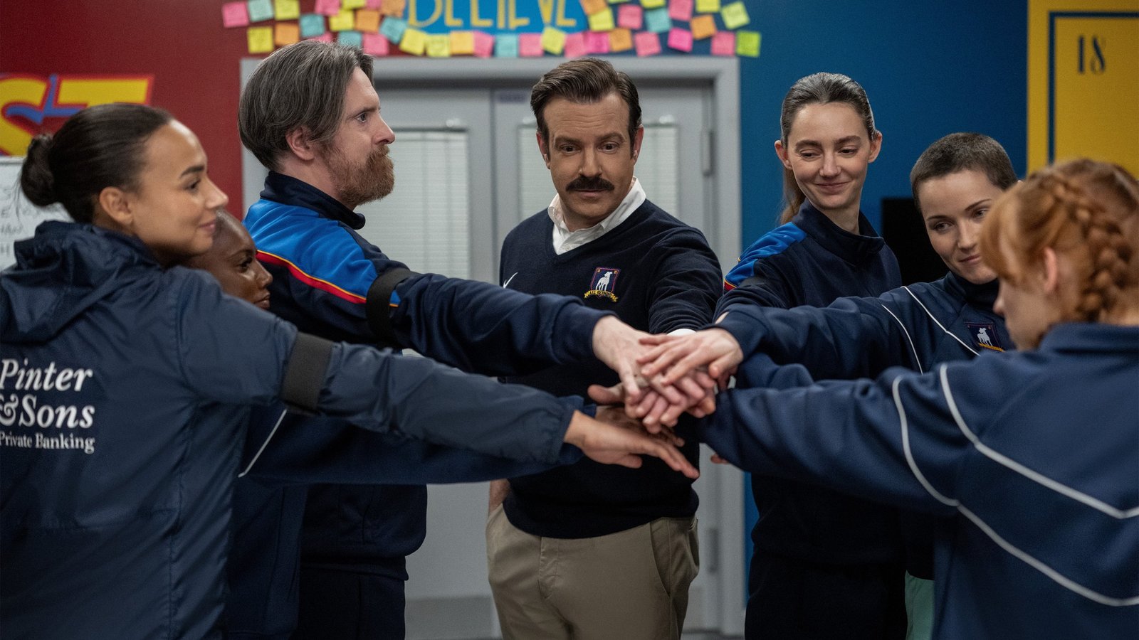 Ted Lasso 4. sezon finali Apple TV resmi karesinden Abbie Hern, Brendan Hunt, Jason Sudeikis, Tanya Reynolds ve Jude Mack el ele