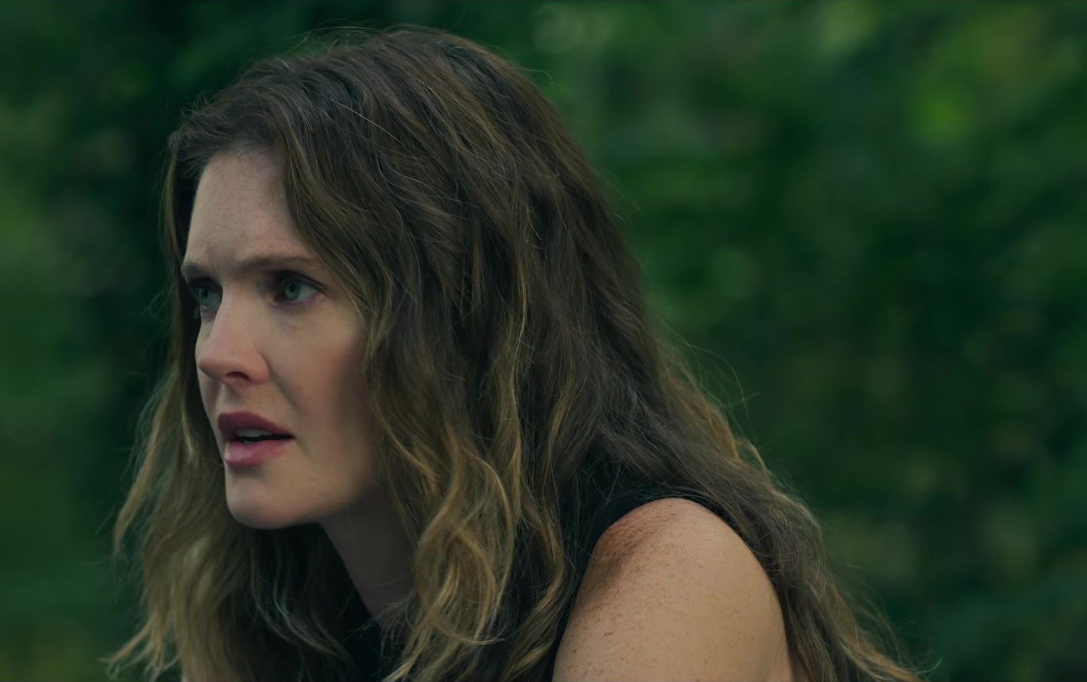 The Good Daughter fragmanından açık havada endişeyle yan tarafa bakan dalgalı saçlı Charlie Quinn rolündeki Meghann Fahy