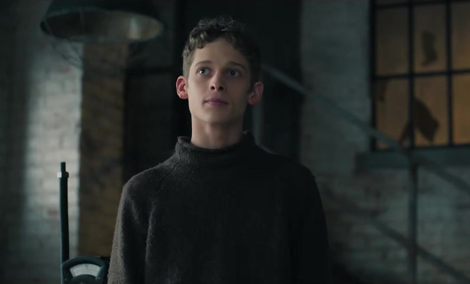 The Institute 2. sezon 8 Kasım’da MGM+’ta: Stephen King uyarlamasına Alfie Allen katılıyor 2026 – 1 The Institute 2. sezon fragmanından loş bir tuğla avluda koyu balıkçı yaka kazağıyla duran Luke Ellis rolündeki Joe Freeman